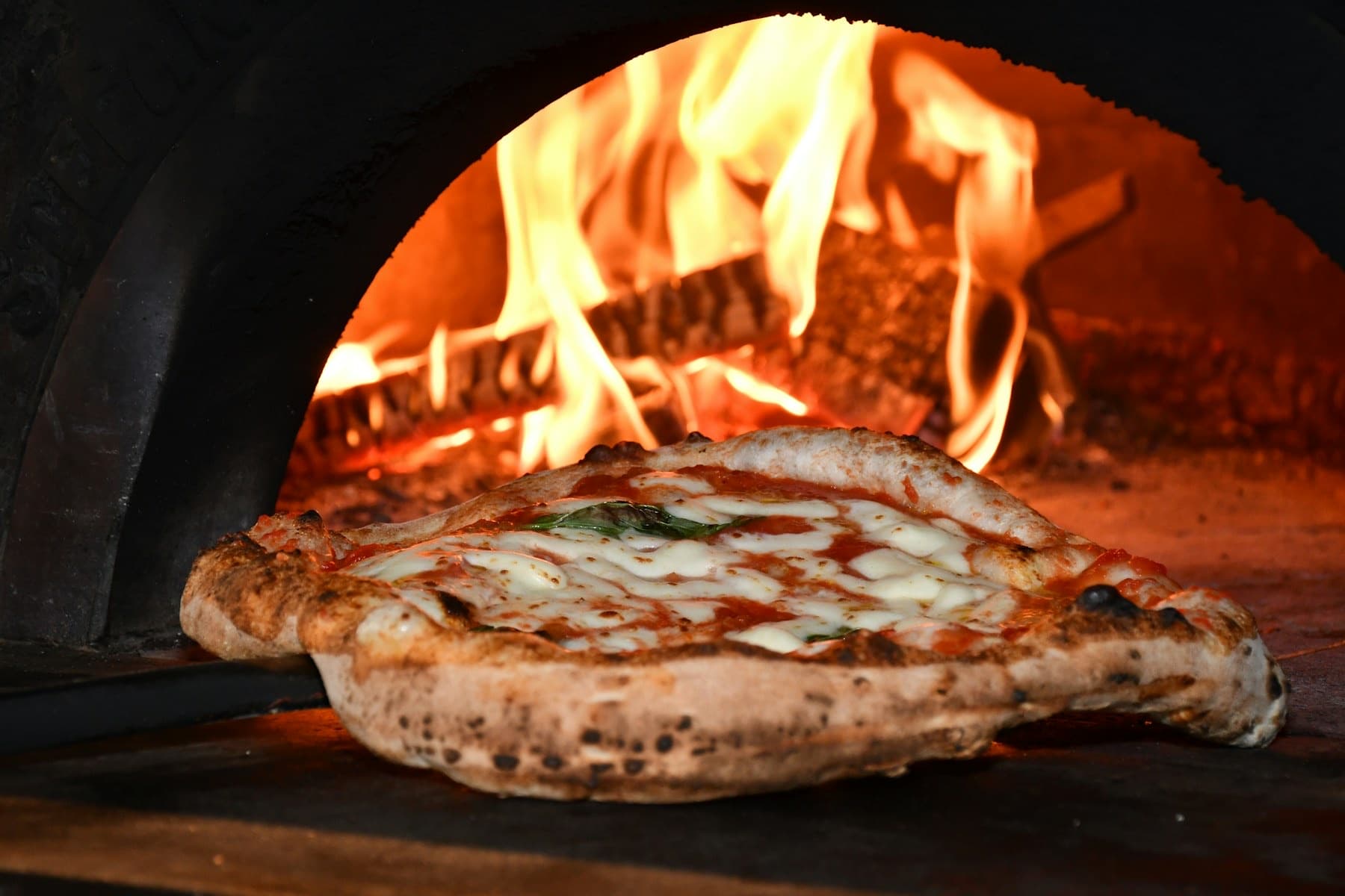 Pizza sortant du four à bois